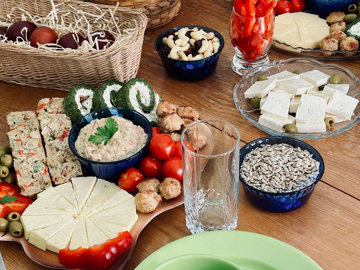 Kalte Platte mit Aufstrichen, Käse, Tomaten und Brot auf einem Holztisch